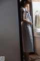 A woman standing in a bathroom next to a sink.