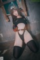 A woman in a black bodysuit and thigh high stockings posing for a picture.