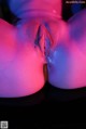 A close up of a woman's butt with a pink light on it.