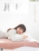 A woman laying on top of a bed with a pillow.