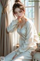 a woman sitting on a window sill next to a teddy bear