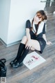 A woman sitting on the floor next to a book.