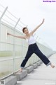 A woman jumping in the air with her arms outstretched.