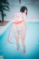 A woman in a clear dress standing in a pool.