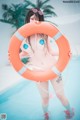 A woman in a bikini holding a life preserver in a pool.