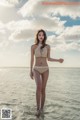 A woman in a bikini standing in the ocean.